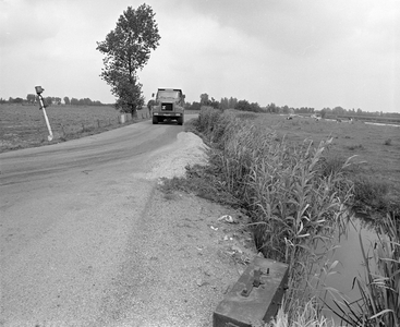882764 Gezicht over de Slotlaan bij het buurtschap Mastwijk te Montfoort, met een met zand geladen vrachtwagen.